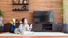 Japanese woman in the living room, wondering what show to watch next.