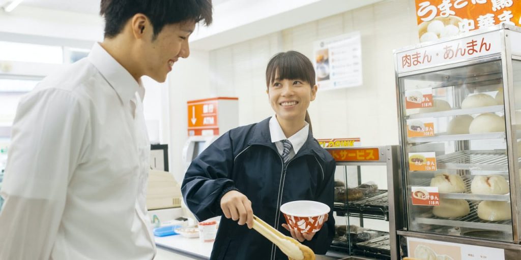 Foreign convenience store clerk helping a Japanese customer