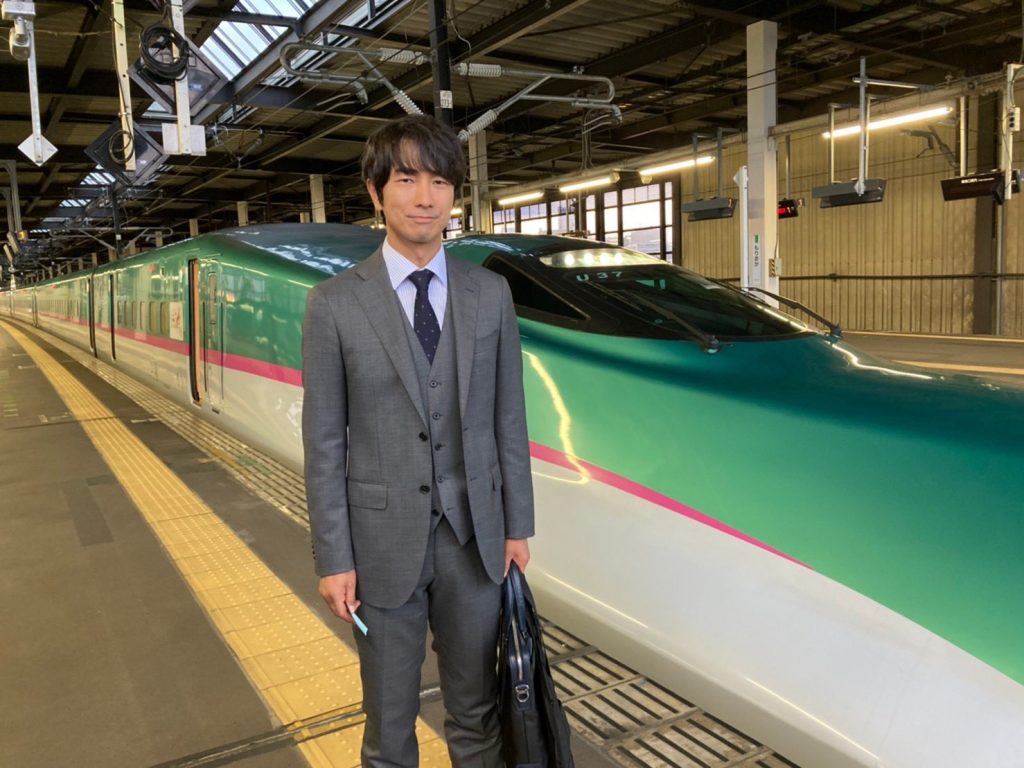 Actor Hideharu Mashima in front of a bullet train