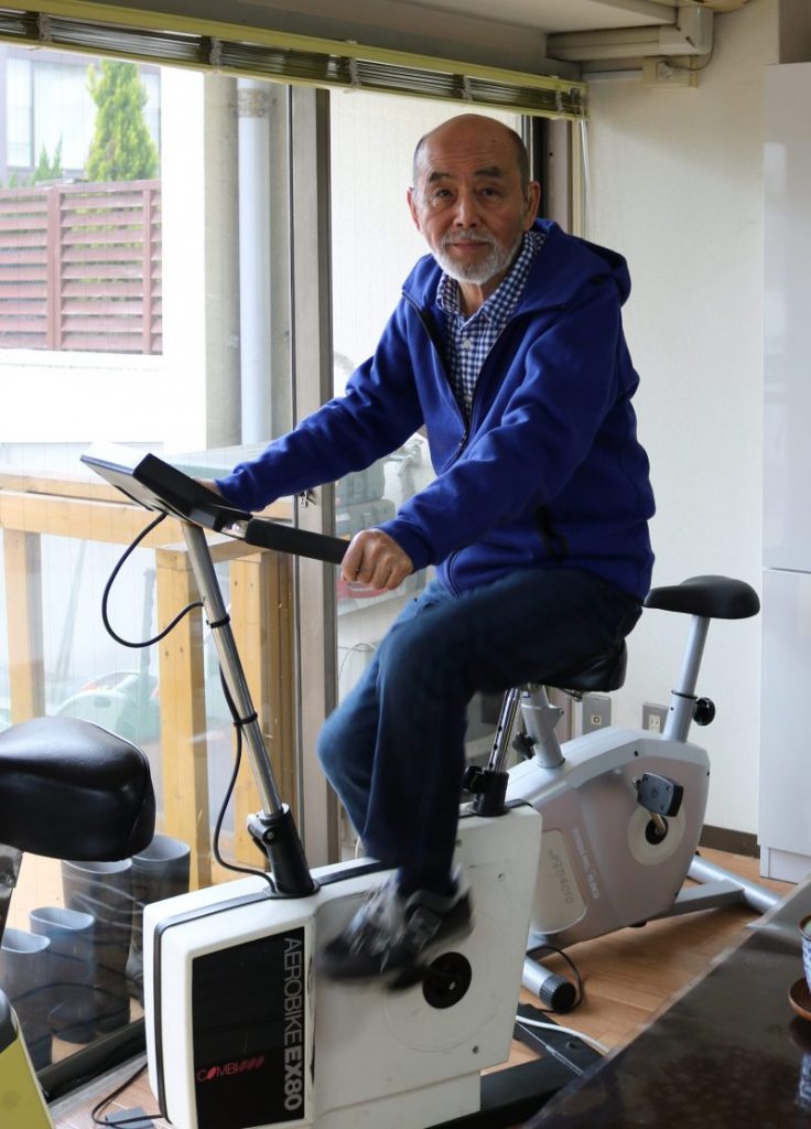 An active senior riding a stationary bike in Japan